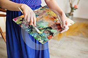 palette with paintbrush and palette-knife in artistÃ¢â¬â¢s hands. photo
